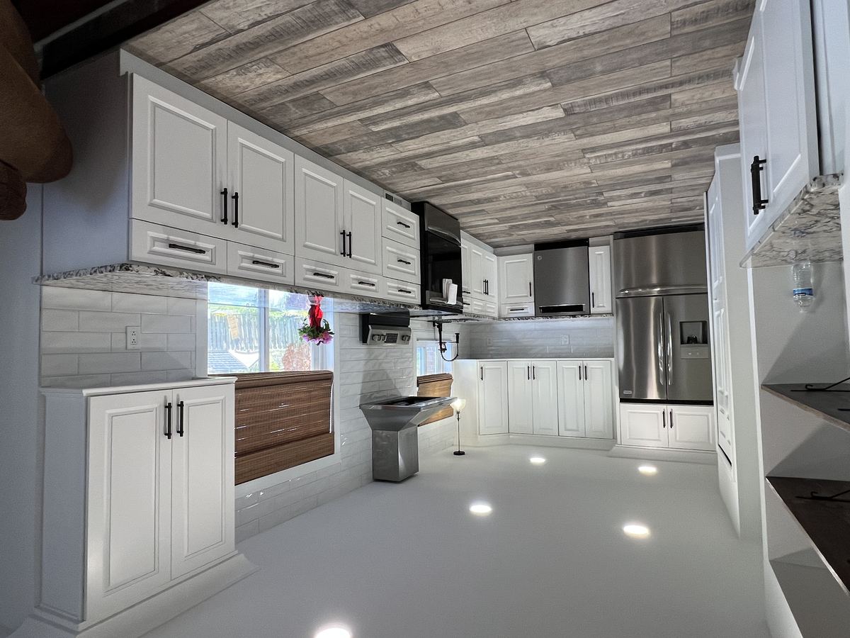 Renovated chef kitchen with white shaker cabinets, granite counters, and stainless appliances