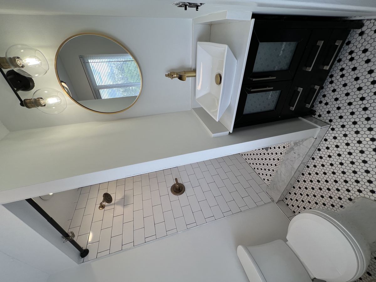 Main bathroom — glass accent wall and rain shower head with white subway tile