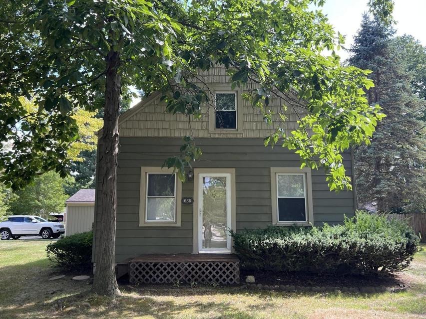 Front exterior of 686 Troywood Drive, Troy MI — bungalow on a corner lot shaded by mature trees